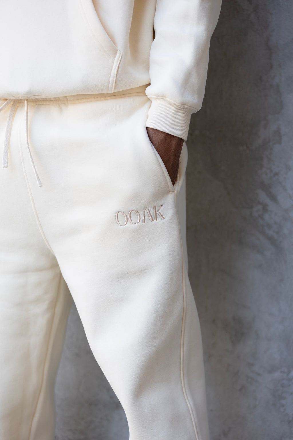 White tracksuit with 'GOAK' branding on a gray background