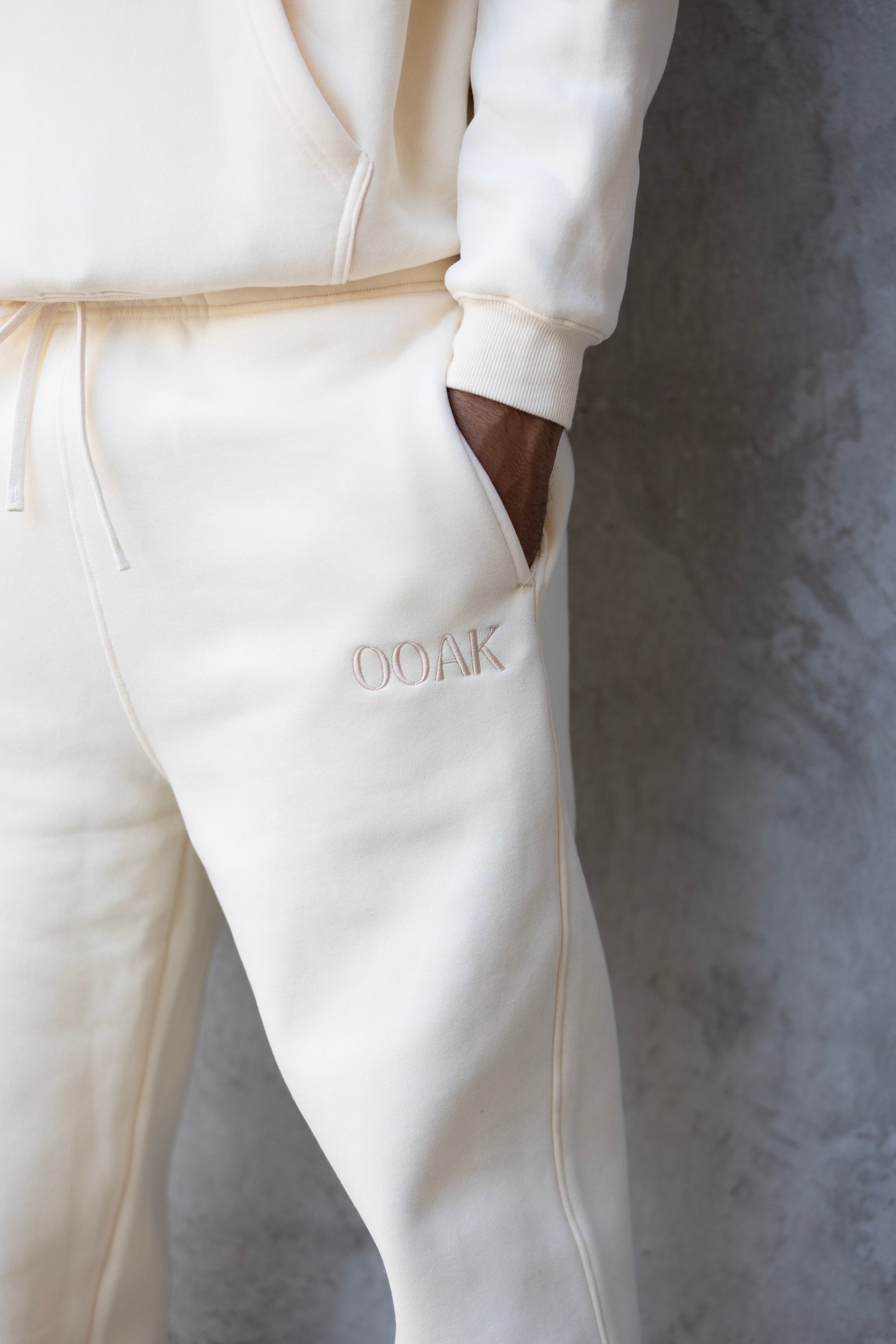 White tracksuit with 'GOAK' branding on a gray background