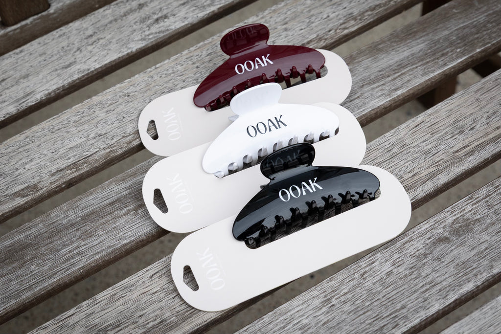 Set of hair clips with 'OOAK' branding on a wooden surface