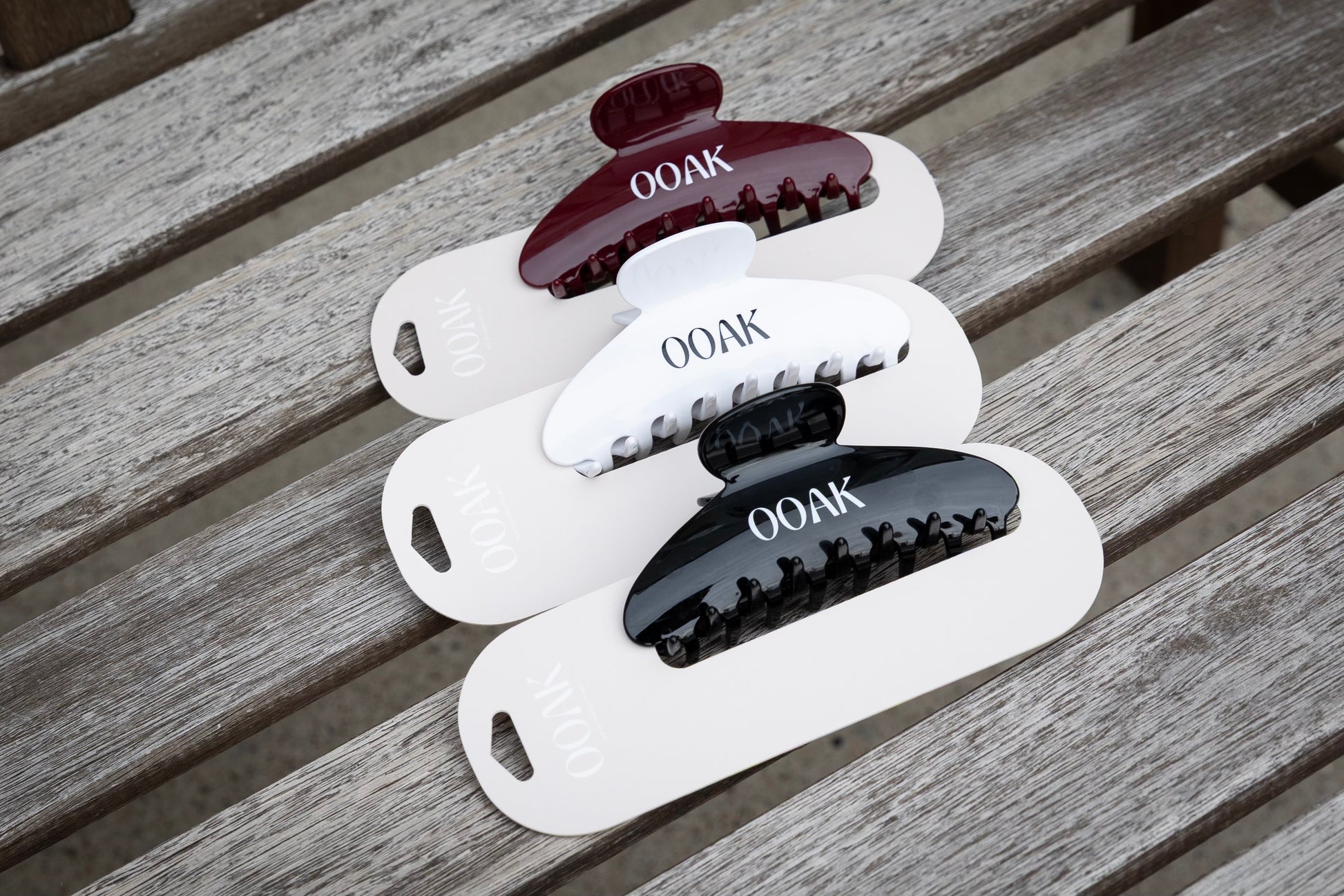 Set of hair clips with 'OOAK' branding on a wooden surface