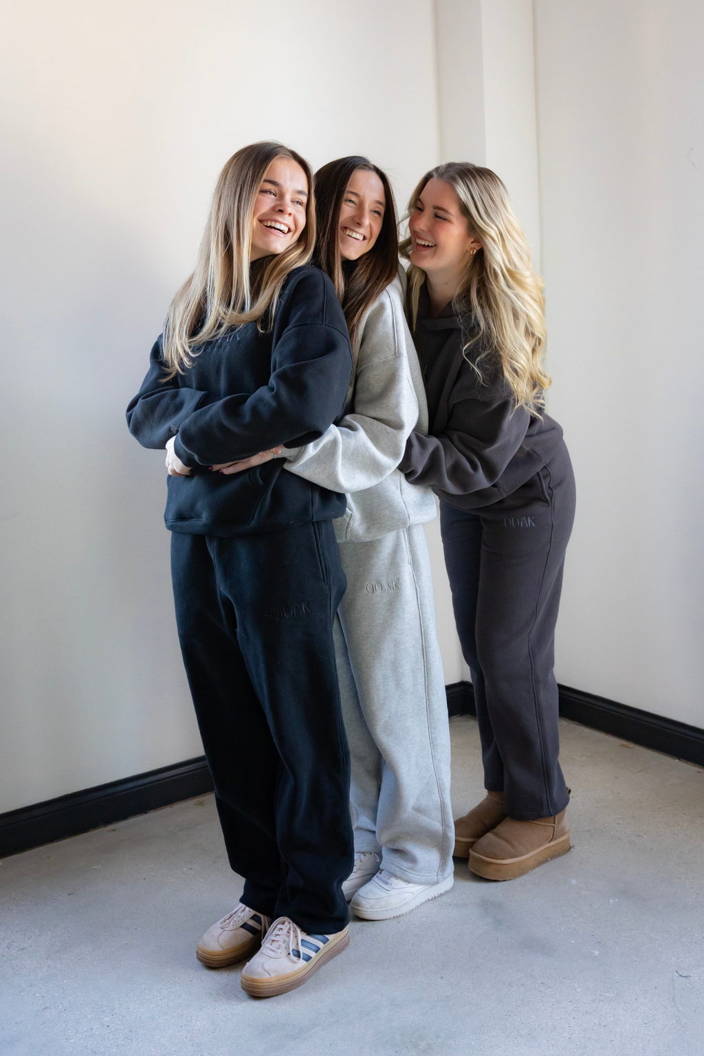 Three models standing together against a white wall, wearing matching OOAK outfits.