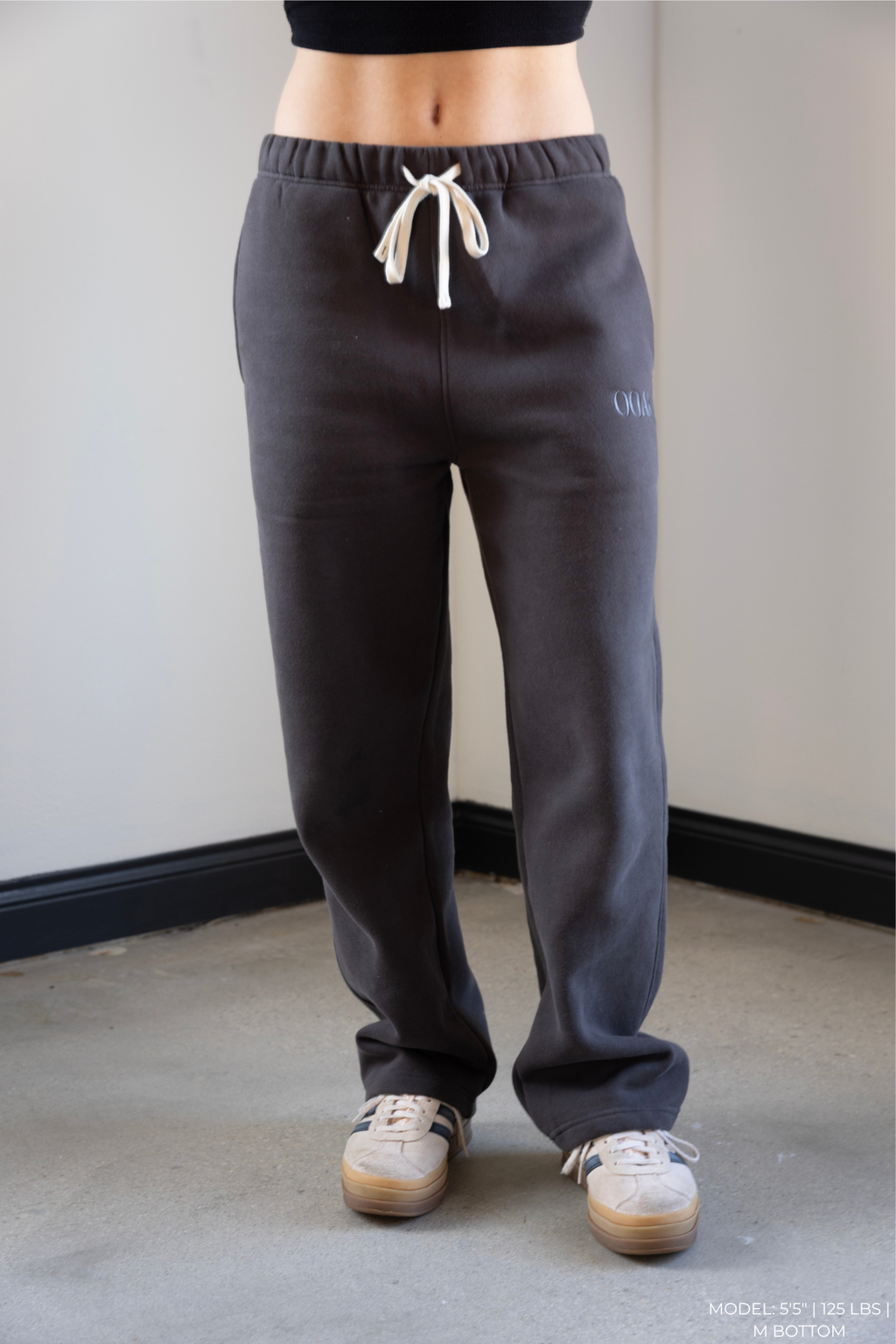 Model wearing gray OOAK sweatpants with a white background