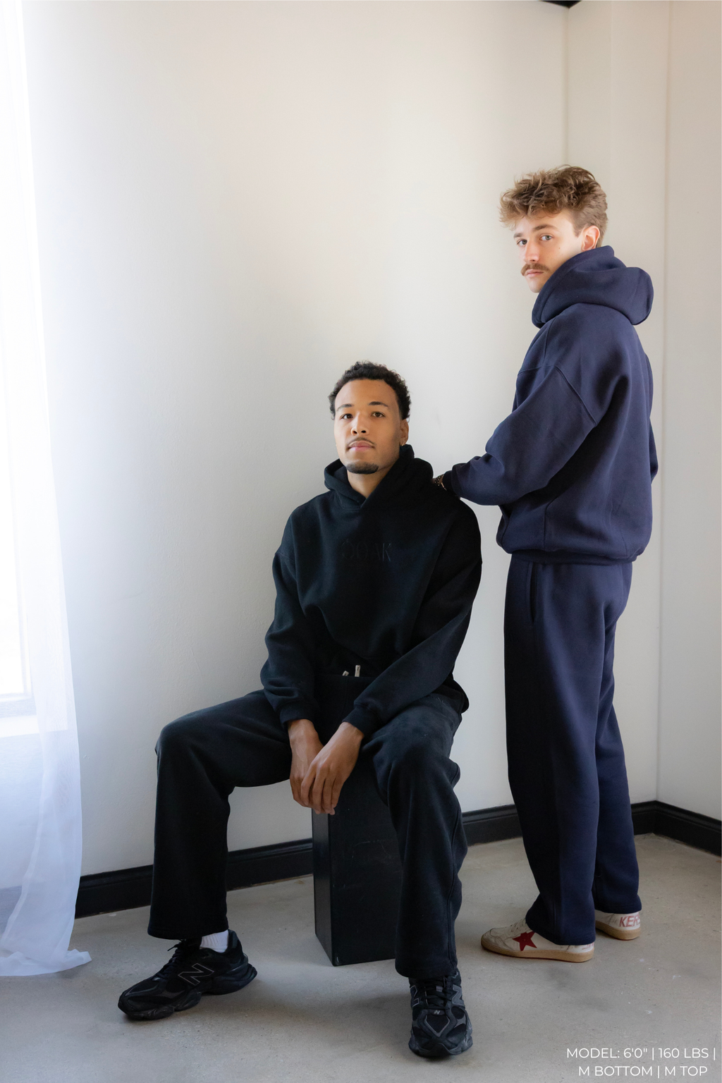 Two models wearing matching navy blue OOAK sets in a minimalistic setting.