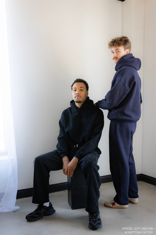 Two models wearing matching navy blue OOAK sets in a minimalistic setting.