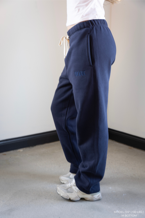 Navy blue OOAK sweatpants worn by a model on a plain background