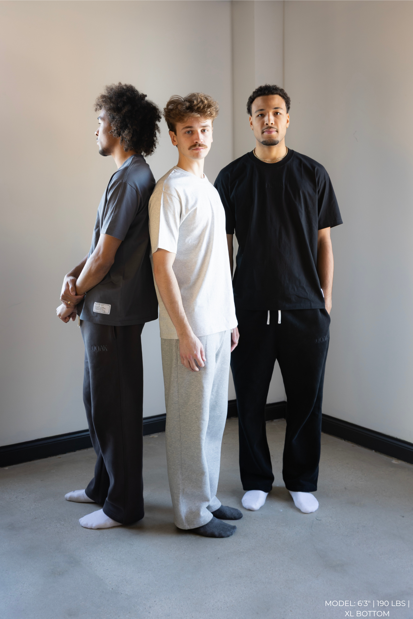 Three OOAK standing side by side against a plain wall.